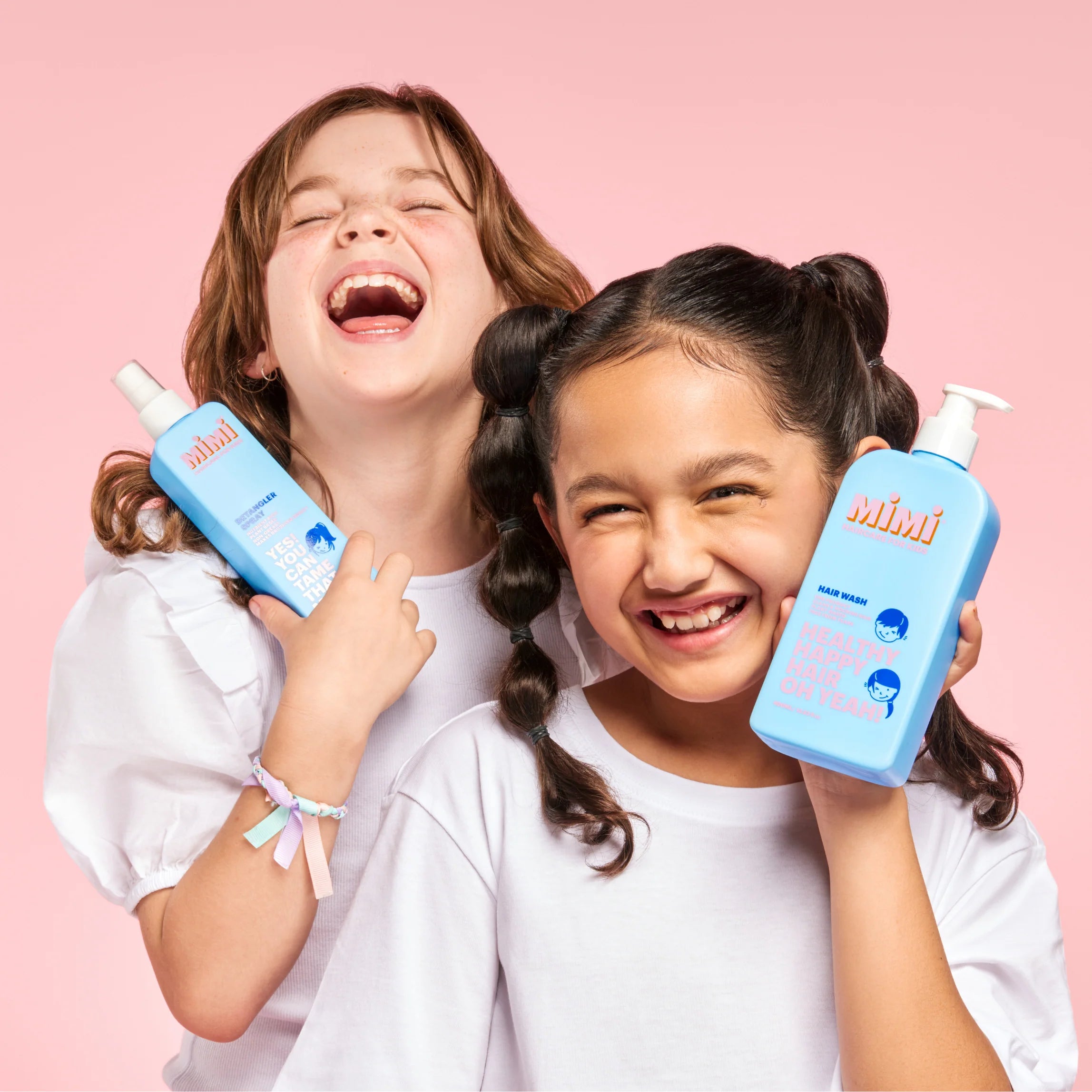 2 girls laughing with mimi haircare